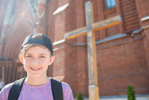 Foto portrait of a 12 year old happy boy in front of a Catholic church