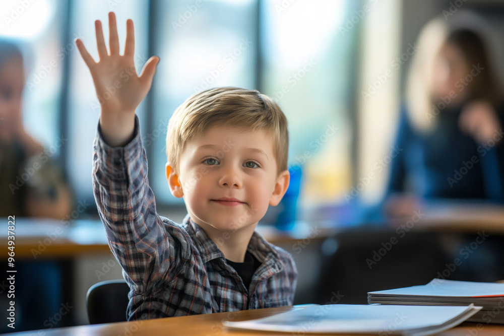 Young boy raising his hand confidently in a brightly lit classroom while smiling at the teacher Young boy raising his hand confidently in a brightly lit classroom while smiling at the teacher