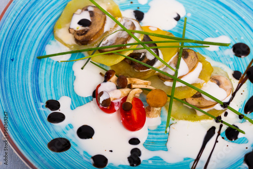 Baked potatoes slices with mushrooms and Provencal herbs served with cream sauce and fresh tomatoes