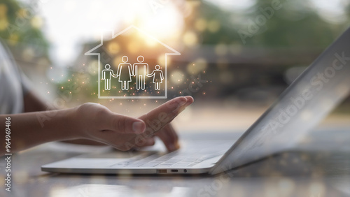 A person is holding a laptop and a house is shown on the screen