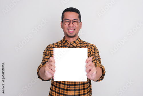 A man smiling happy while showing blank book page in front of his chest photo