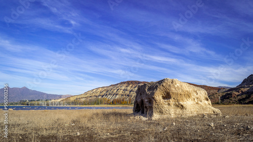 
We see a beautiful landscape of the mouth of the Mendoza River in the Potrerillos dam, in the background mountains and clouds of great textures, also in the foreground a large rock photo