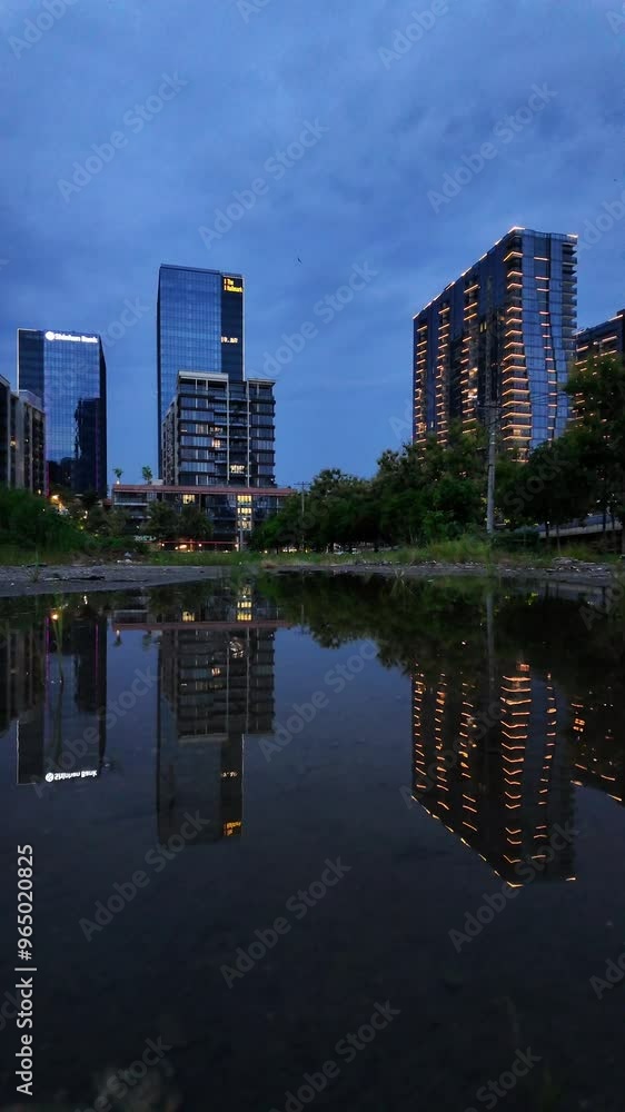 Asia big city with high rise building illuminated by light at twilight and reflect on water surface, luxury building with modern architecture at Ho Chi Minh at finance center Asia big city with high rise building illuminated by light at twilight and reflect on water surface, luxury building with modern architecture at Ho Chi Minh at finance center