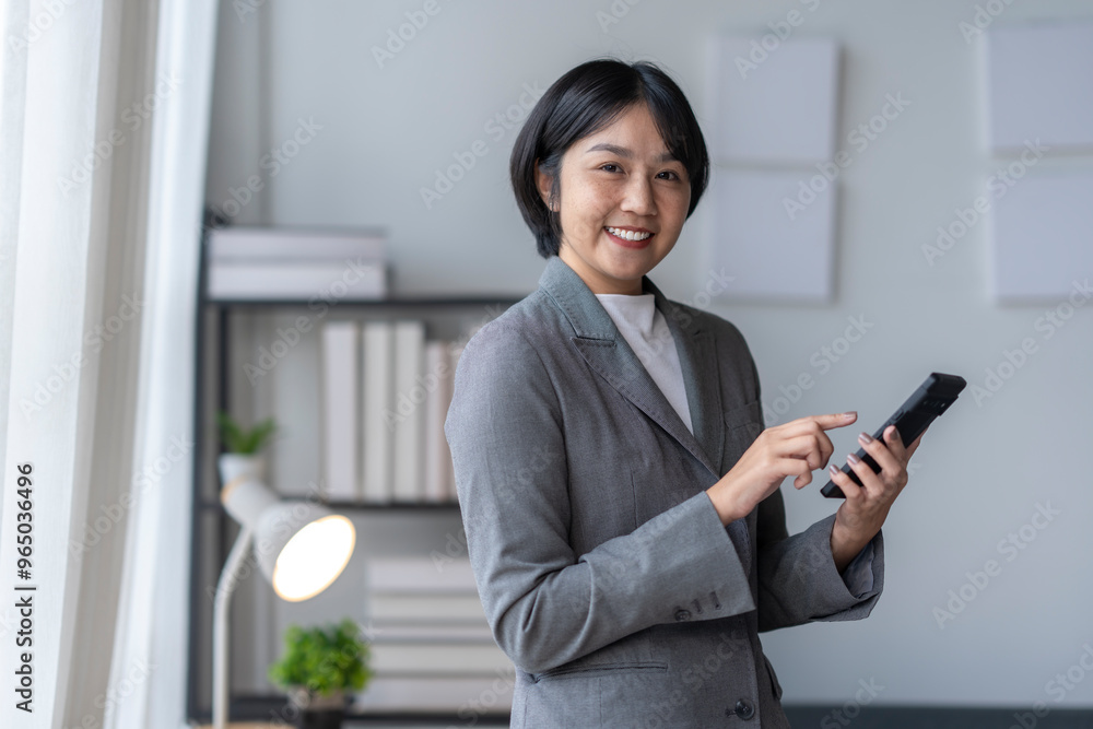Smiling asian businesswoman using smartphone in modern office Smiling asian businesswoman using smartphone in modern office