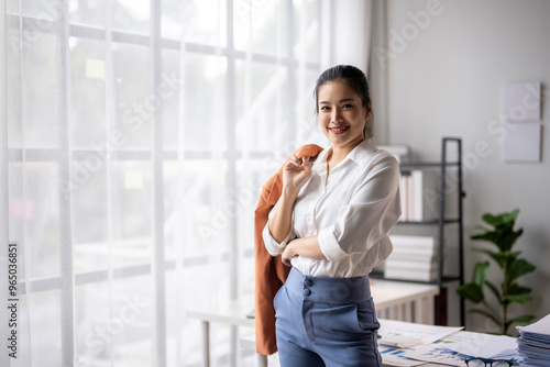 Free Download Young businesswoman smiling while holding her jacket in a modern office - GFXLoad