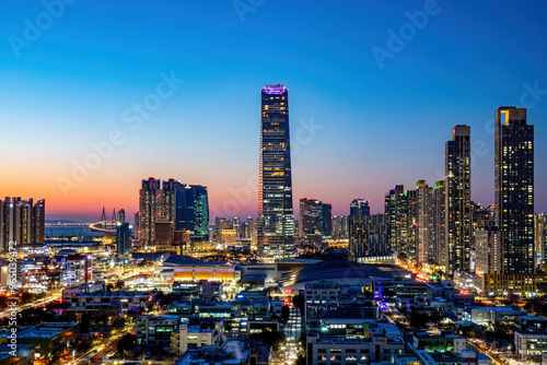 Song-do, Yeonsu-gu, Incheon, South Korea - January 8, 2021: Panoramic and night view of highrise apartments and POSCO Tower with the background of Incheon Bridge