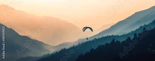 Paraglider over misty mountains at sunset