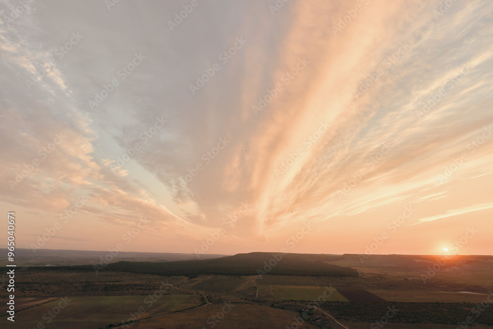 Sunset serenity aerial view of tranquil field, trees, and hills in background for travel and nature concepts Sunset serenity aerial view of tranquil field, trees, and hills in background for travel and nature concepts