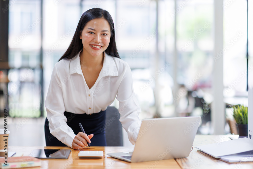 Business asian woman or female worker using a laptop computer to analyse her financial data.business people research or financial strategy in company concept. Laptop white screen mockup. Business asian woman or female worker using a laptop computer to analyse her financial data.business people research or financial strategy in company concept. Laptop white screen mockup.