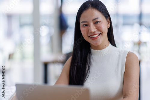 Business asian woman or female worker using a laptop computer to analyse her financial data.business people research or financial strategy in company concept. Laptop white screen mockup.