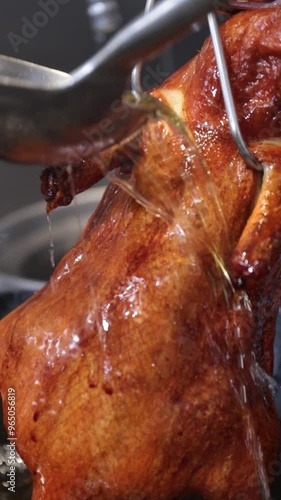 chef puring hot oil on roast duck