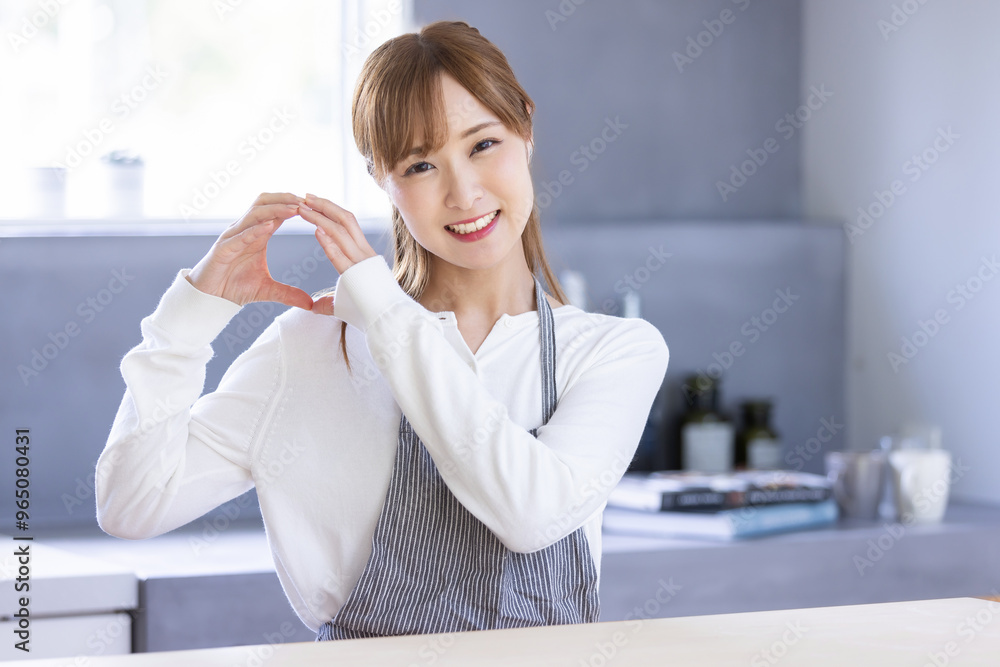 キッチンでハンドサインする女性 キッチンでハンドサインする女性
