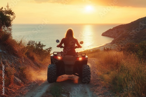 Woman driving quadbike at sunset by the sea