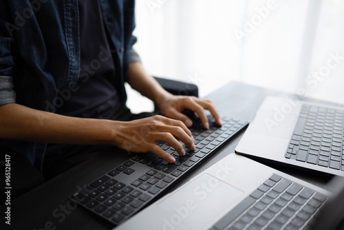 Asian man software engineer Working on Computer at office desk for writing program code IT Software Engineer finding errors tech support devops creating digital