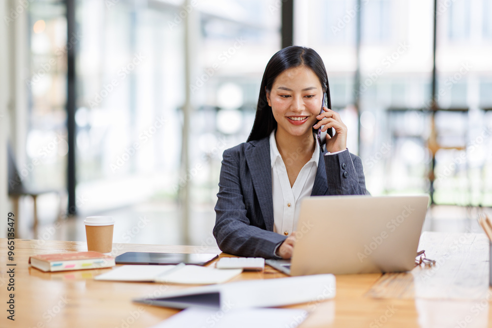 Business Asian woman freelancer is working her job on a laptop computer and phone call in the office. Doing accounting analysis report real estate investment data, Financial and tax systems concept. Business Asian woman freelancer is working her job on a laptop computer and phone call in the office. Doing accounting analysis report real estate investment data, Financial and tax systems concept.