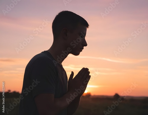 Silhouette of a person praying at sunset with vibrant skies and mountains in the background