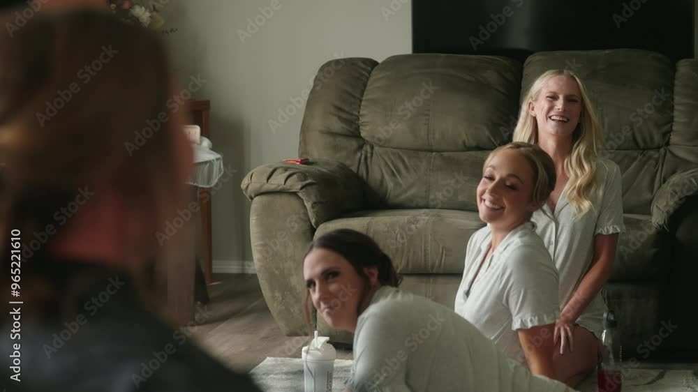 Over-the-shoulder view of bride as her bridesmaids smile laugh reacting to look Over-the-shoulder view of bride as her bridesmaids smile laugh reacting to look