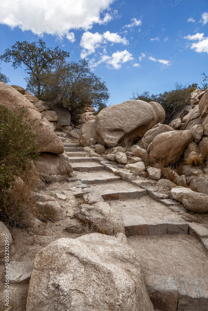 A stone staircase leads hikers through desert vegetation on the Barker Dam Trail in Joshua Tree National Park, California. A stone staircase leads hikers through desert vegetation on the Barker Dam Trail in Joshua Tree National Park, California.
