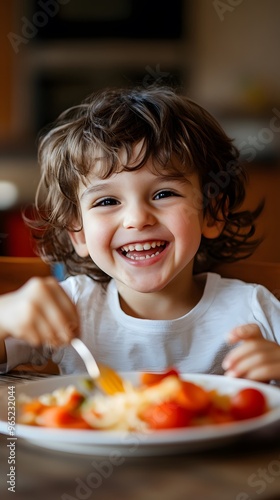 A Happy Young Child Eating Pasta With Cherry Tomatoes