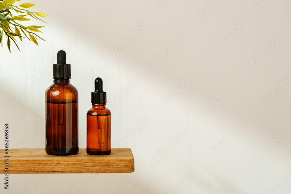Collection of Amber Glass Bottles and Jars for Essential Oils on a White Surface Collection of Amber Glass Bottles and Jars for Essential Oils on a White Surface