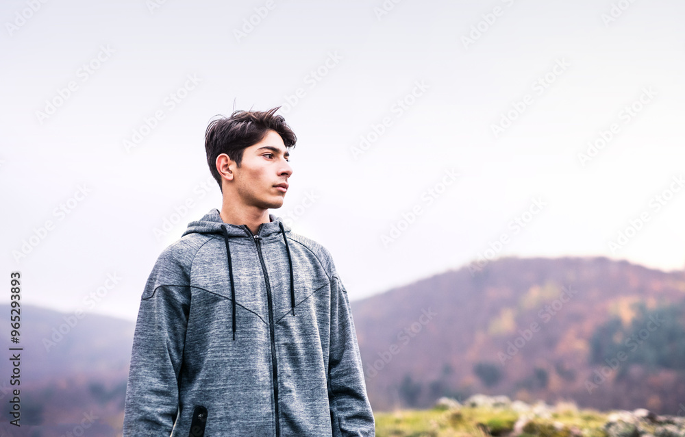 Male runner resting after jog in nature on dirt running trail, enjoying view. Morning running training for young man. Male runner resting after jog in nature on dirt running trail, enjoying view. Morning running training for young man.