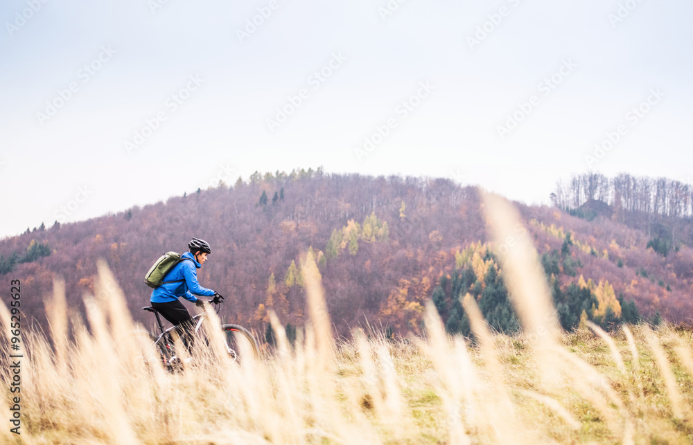 Obraz premium Active man on bike in the middle of beautiful nature, early autumn morning. Concept of healthy lifestyle.