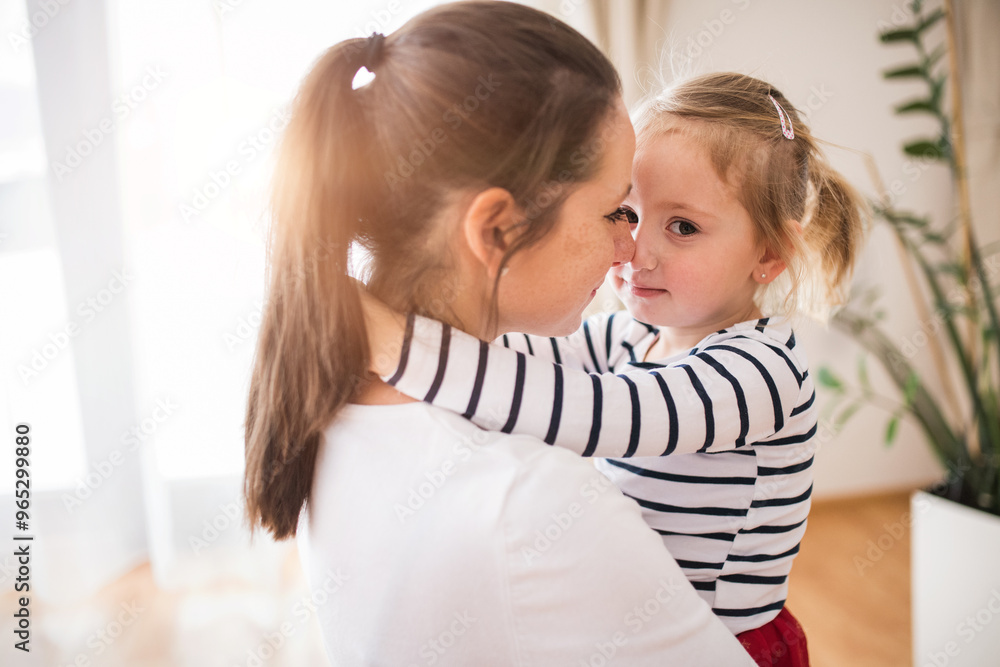 Beatiful young mother hugging little daughter, touching with noses. Beatiful young mother hugging little daughter, touching with noses.