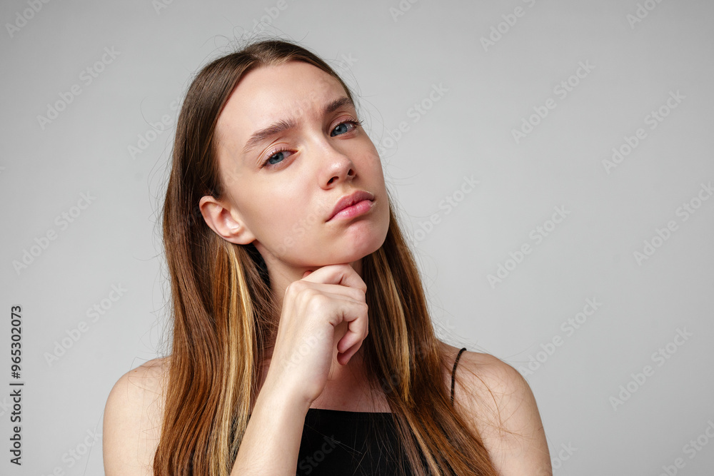Young Woman With Long Brown Hair Posing Thoughtfully Against White Background Young Woman With Long Brown Hair Posing Thoughtfully Against White Background