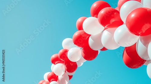 Festive red and white balloon arch on a clear blue sky background, creating a vibrant and eyecatching display for Canada Day celebrations with room for text photo