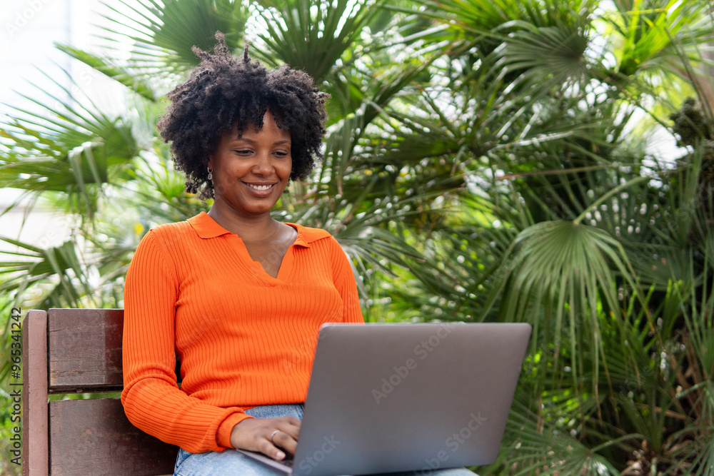 Smiling woman sitting with laptop at park Smiling woman sitting with laptop at park