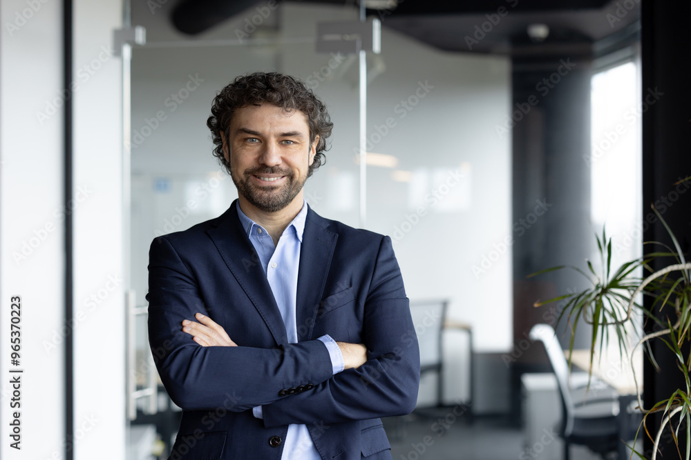 Businessman with confident smile and crossed arms in bright modern office. Emphasizes leadership qualities, professionalism. Ideal for business, corporate themes. Businessman with confident smile and crossed arms in bright modern office. Emphasizes leadership qualities, professionalism. Ideal for business, corporate themes.
