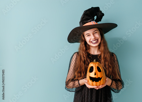 girl in witch costume with Halloween pumpkin