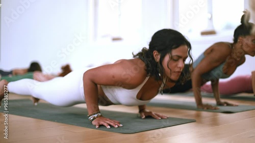 Slow-motion video of a diverse group practicing upward-facing dog pose during a yoga session.