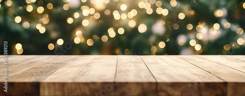 Christmas background with close up of wooden table with snowy christmas trees and sparkling lights in the background