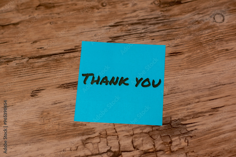 Blue thank you note on a wooden desk. Blue thank you note on a wooden desk.