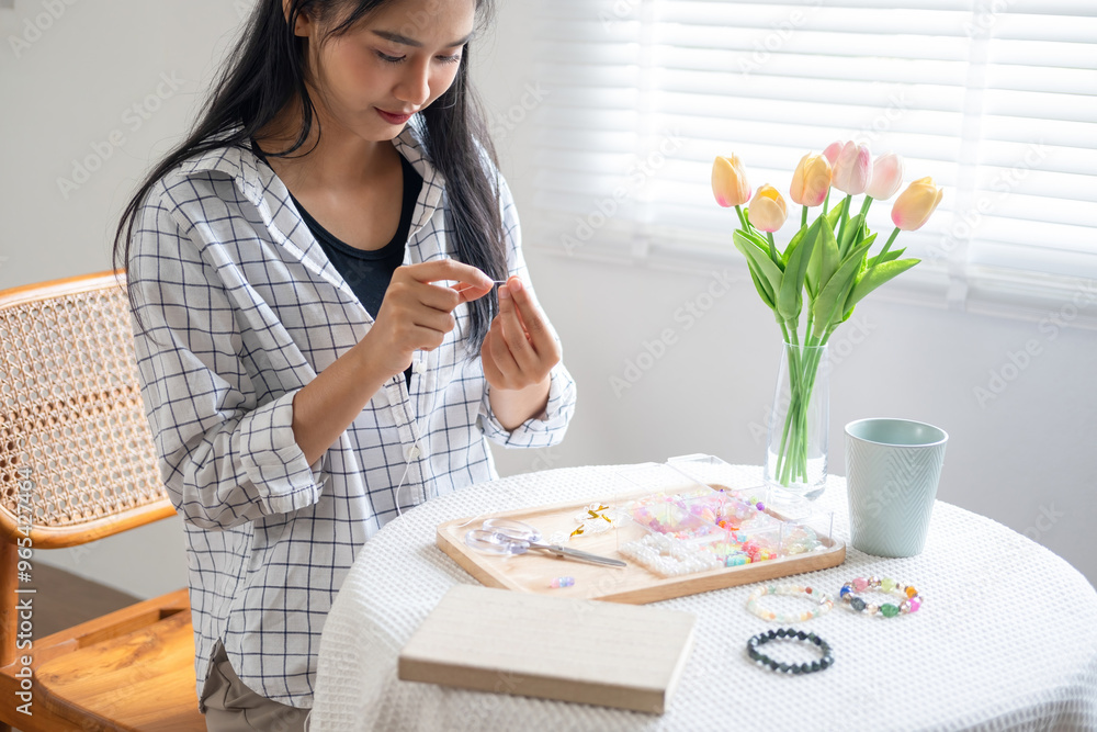 Young girl making handmade bracelets with fun and cheerfulness Young girl making handmade bracelets with fun and cheerfulness