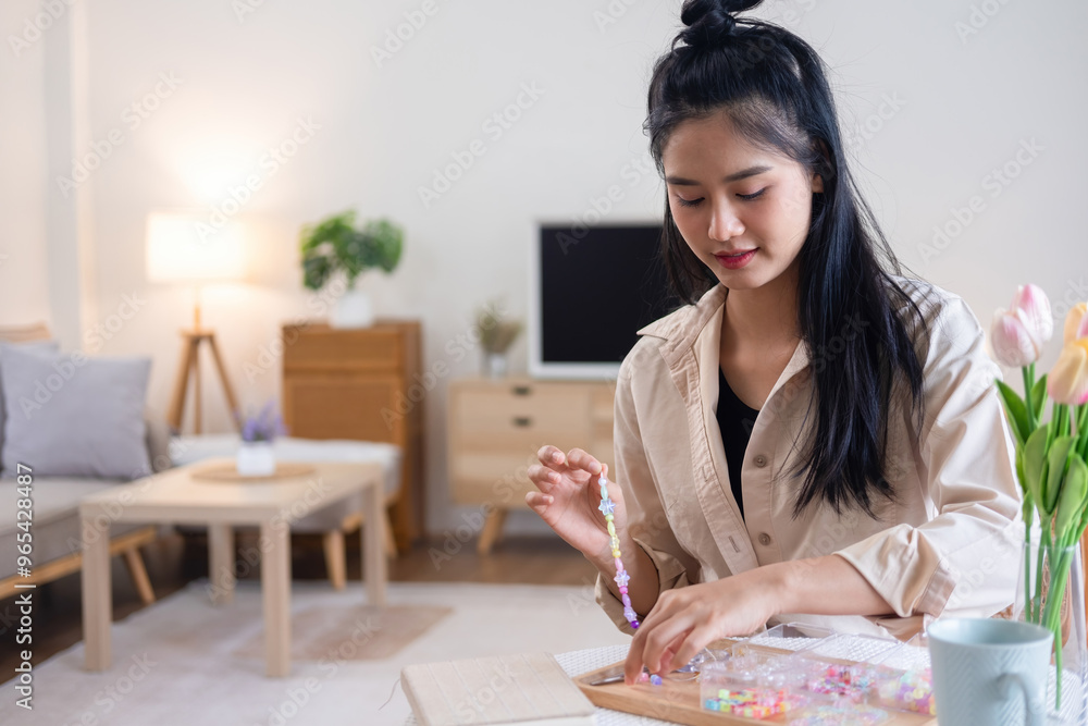 Young girl making handmade bracelets with fun and cheerfulness Young girl making handmade bracelets with fun and cheerfulness