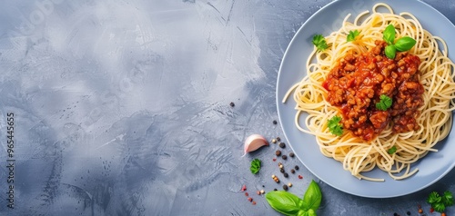 Delicious plate of spaghetti topped with rich bolognese sauce and fresh herbs on a gray textured background. photo