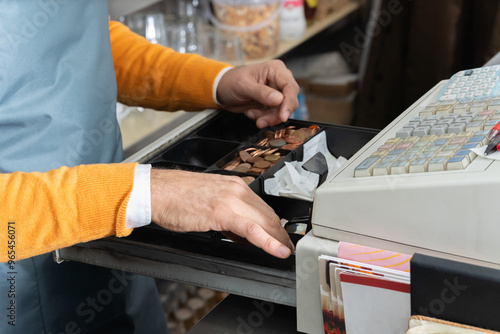 Cashier´s hands searching for change in an open cash register. Business concept