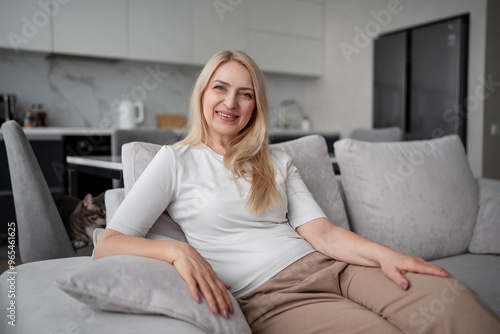 A woman is peacefully lounging on a couch in a contemporary home with simple and clean design