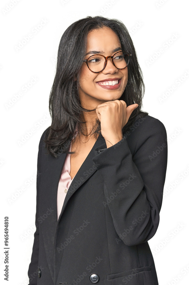 Young Latina professional in studio points with thumb finger away, laughing and carefree. Young Latina professional in studio points with thumb finger away, laughing and carefree.