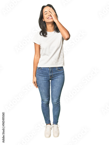 Full body shot of Latina in studio laughing happy, carefree, natural emotion.