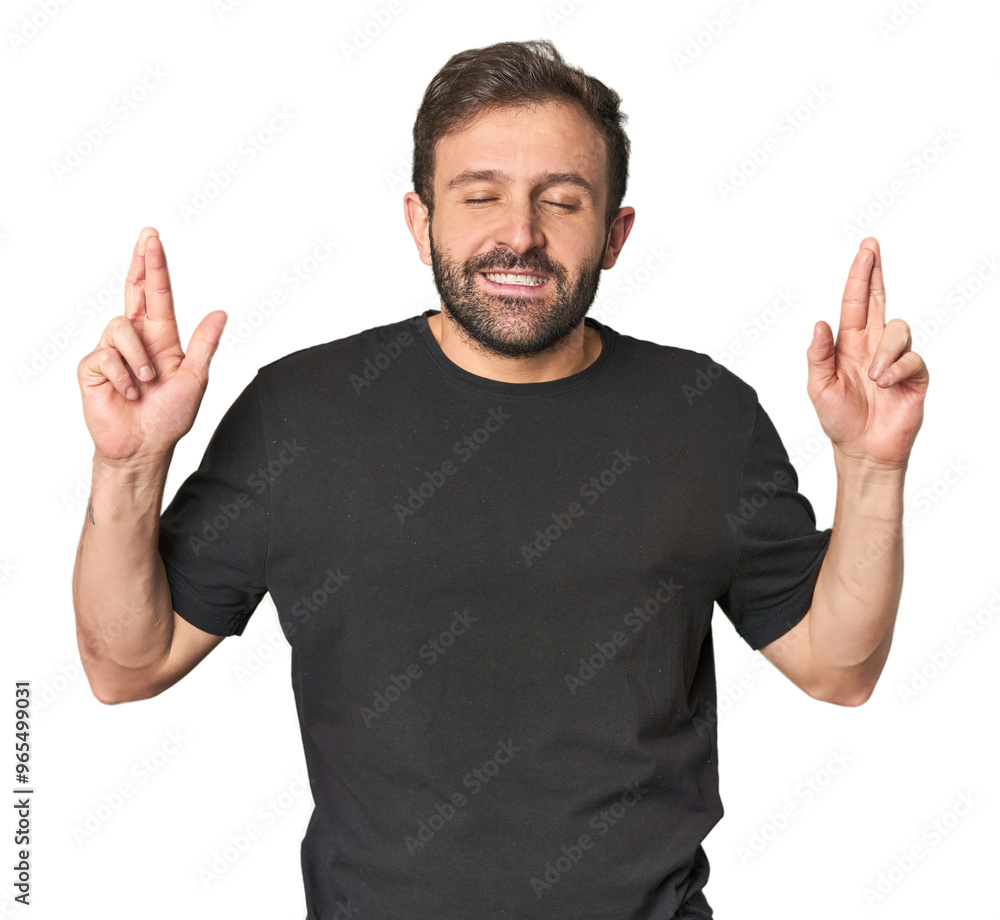 Studio portrait of young Hispanic male crossing fingers for having luck Studio portrait of young Hispanic male crossing fingers for having luck