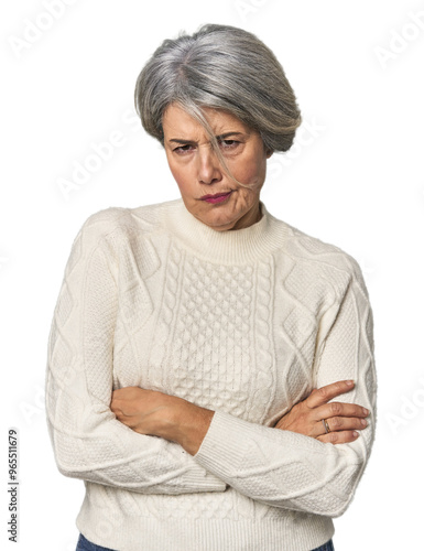 Caucasian mid-age female on studio background unhappy looking in camera with sarcastic expression.