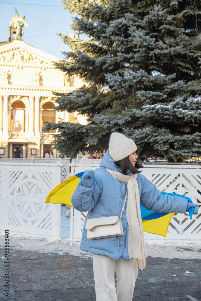 woman covered with ukrainian flag in front of christmas tree woman covered with ukrainian flag in front of christmas tree