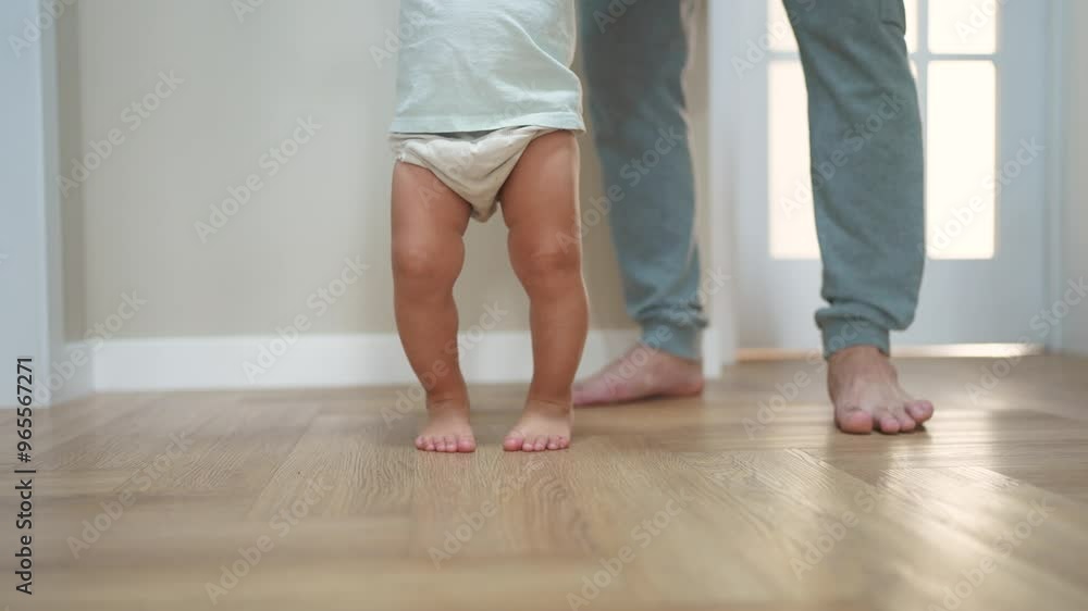 baby first steps. happy family a kid dream concept. father teaches baby daughter to take first steps at home in lifestyle front of window. father's day concept. baby takes his first steps baby first steps. happy family a kid dream concept. father teaches baby daughter to take first steps at home in lifestyle front of window. father's day concept. baby takes his first steps