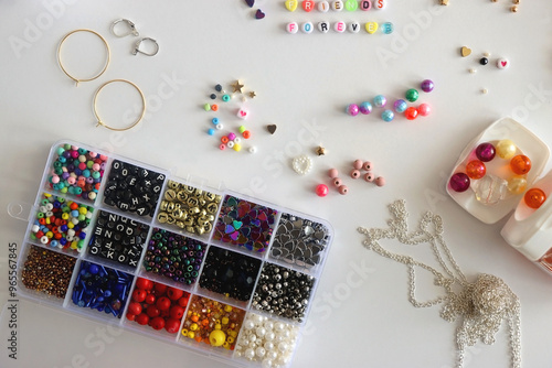 Obraz na płótnie Friends forever written with colorful beads. Jewelry making supplies on the table. Making friendship bracelets concept. Flat lay. w salonie