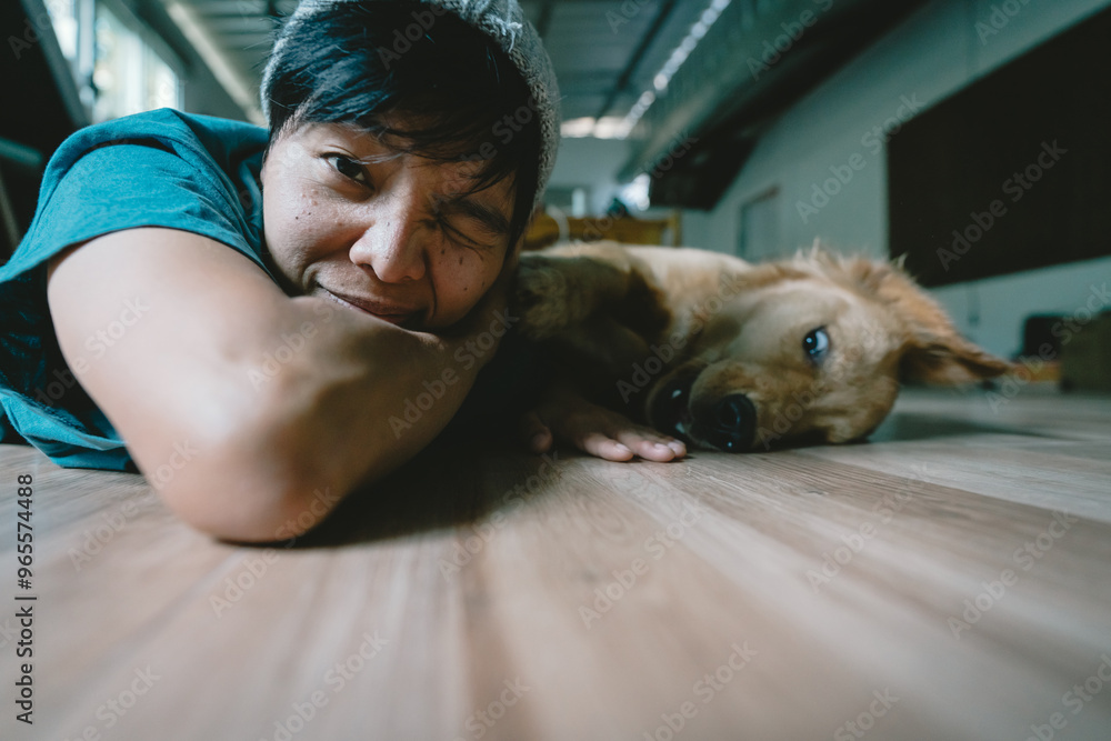 Obraz premium Soft focus blurs the face of the person, Selective focus A real Asian man takes a selfie golden retriever. The dog is playing together Looking funny at the camera at home.