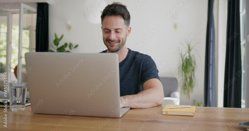 Video of mid adult man using laptop at home sitting at table