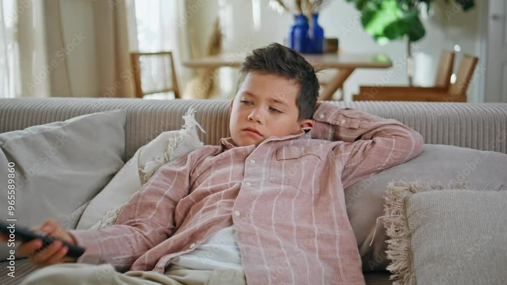 Serious kid switching channels watching cartoons on tv at living room closeup Serious kid switching channels watching cartoons on tv at living room closeup